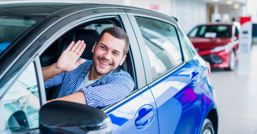 Imagem mostrando um homem jovem feliz ao trocar de carro.
