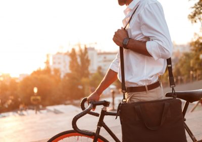 Jovem empresário indo para o trabalho de bicicleta após contratar um seguro para bike.